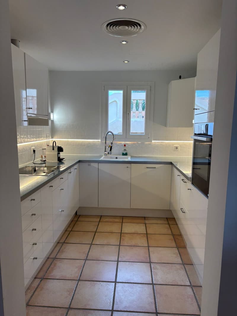 modern kitchen with white cabinetry, tiled backsplash, granite countertops, stainless steel appliances, double sink with gas range