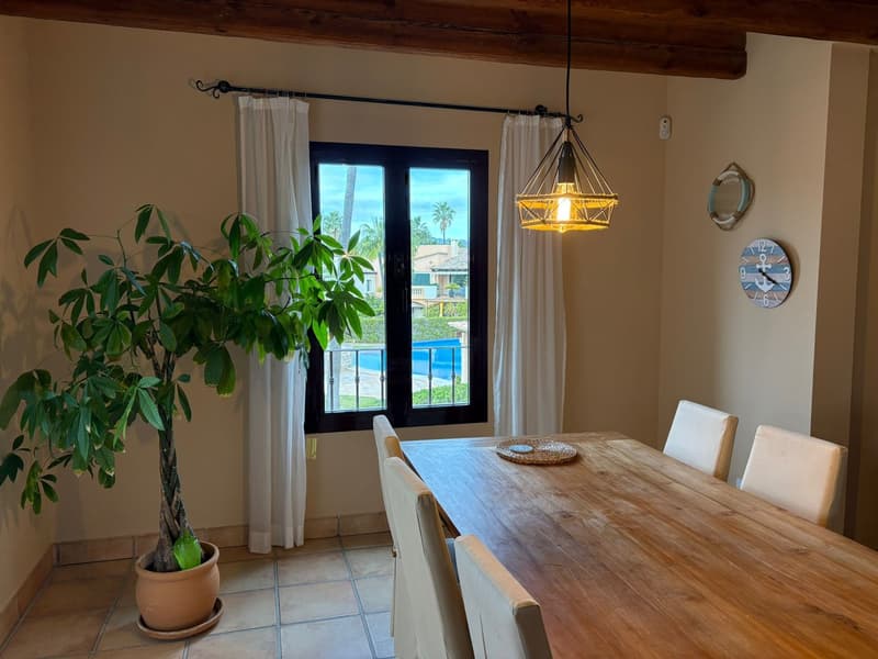 dining room, wooden table, 6 chairs, plant, glass window, balcony, view of pool