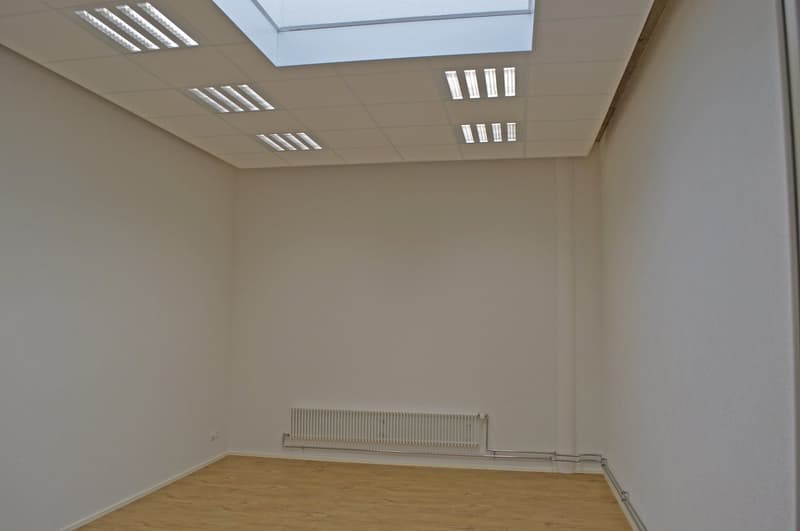 empty room, white walls, wooden floor, white radiator, skylight