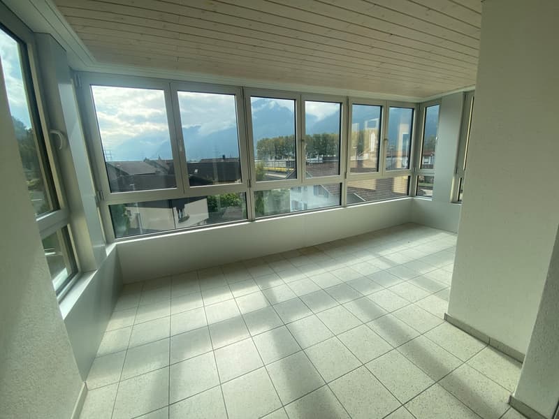 large windows, white tile flooring, view of mountains and buildings