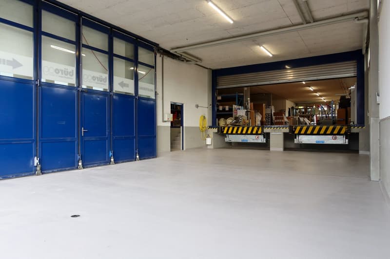 warehouse, large double doors, raised ground floor, white walls, large windows, white floor, storage boxes