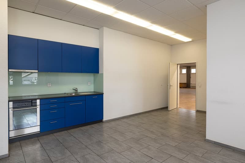 modern kitchen with blue cabinets, stainless steel appliances, tiled floor, open door