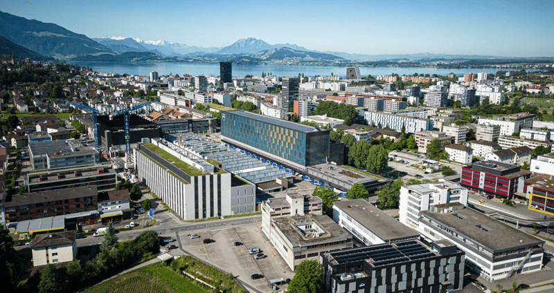urban area with buildings, lake, mountains, cars, crane