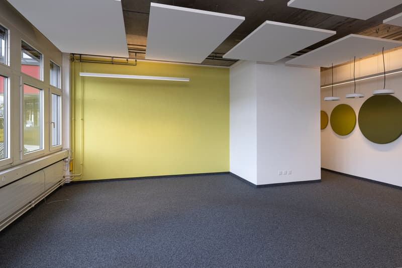 empty room, yellow wall, white ceiling, gray floor, windows, radiator, hanging lamps