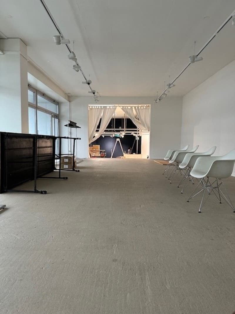 empty hall with white chairs, long desk, curtains