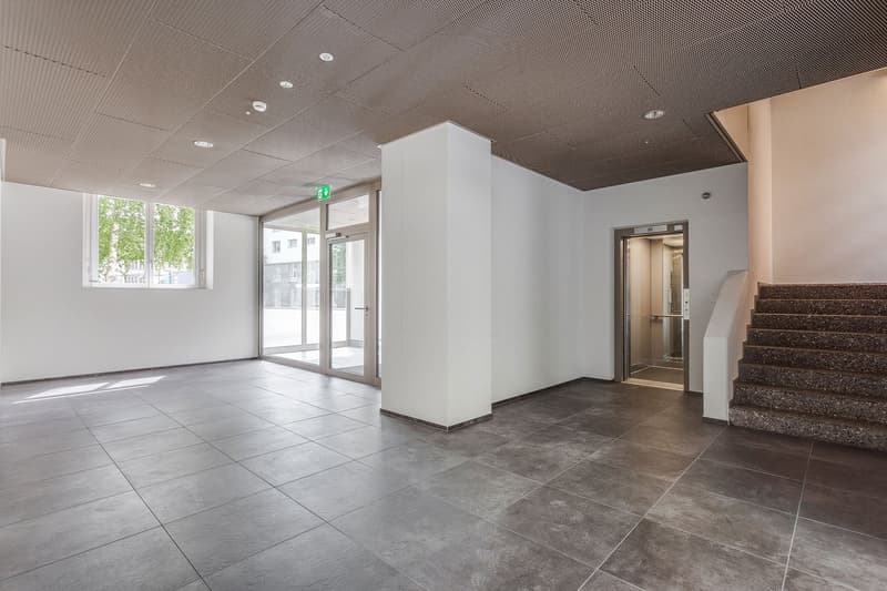 tiled floor, white walls, windows, door, staircase, elevator