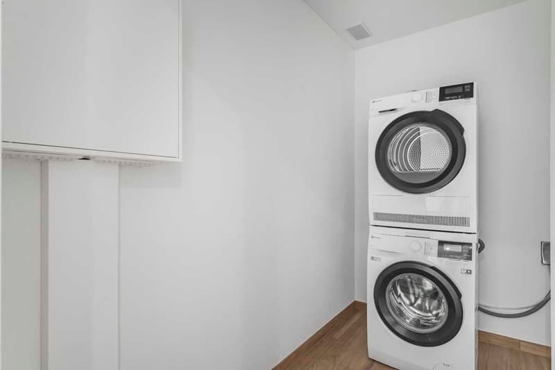 white washing machine, dryer, wall, power outlet, wooden floor