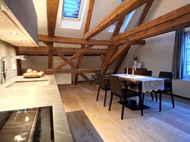 wooden beams, granite counter top, modern sink, wooden dining table, modern chairs, induction cooktop
