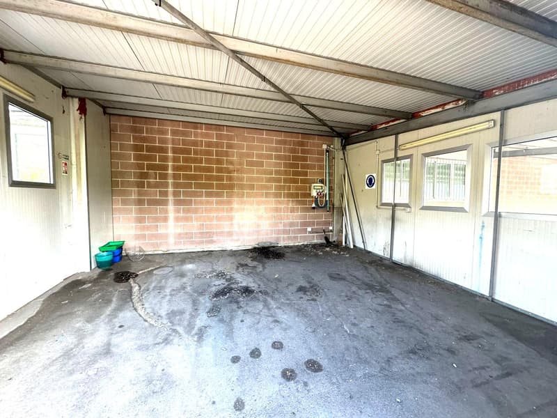 Empty room with brick wall, metal beams, small window, white ceiling, no furniture