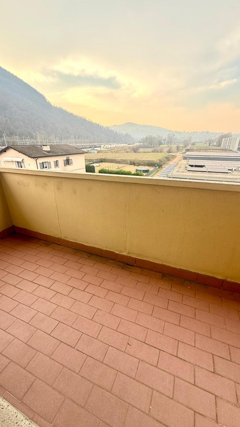 Terraced balcony with brick flooring, view of the countryside and mountains.