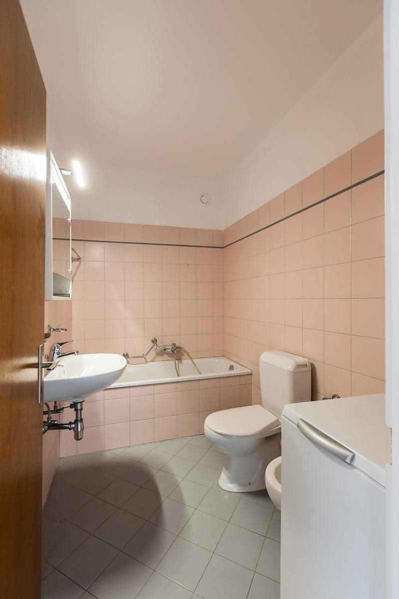 white tiled walls, bathtub, toilet, bidet, sink, mirror, washing machine