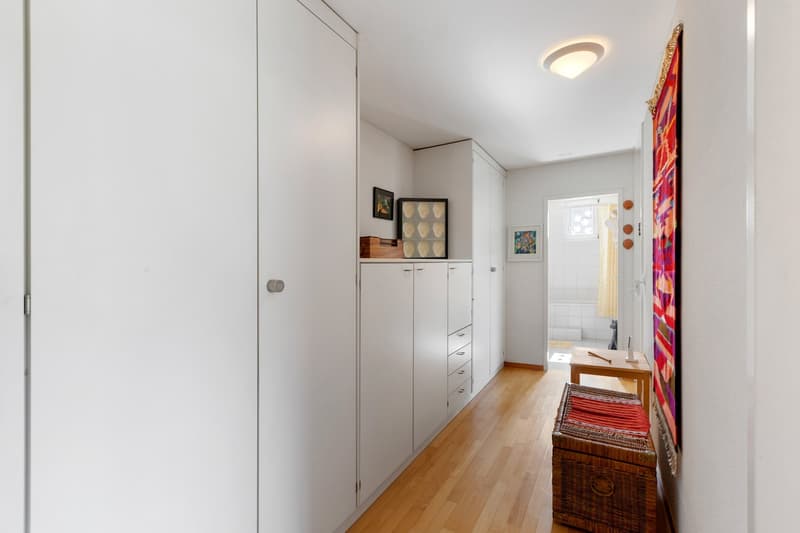wooden floor, white walls, white cabinets, decorative items, ceiling light