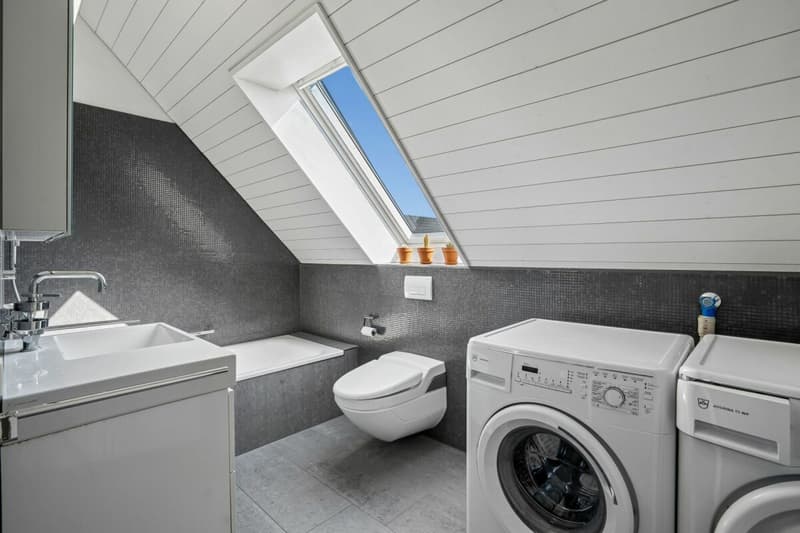 Badezimmer mit Waschmaschine und Tumbler