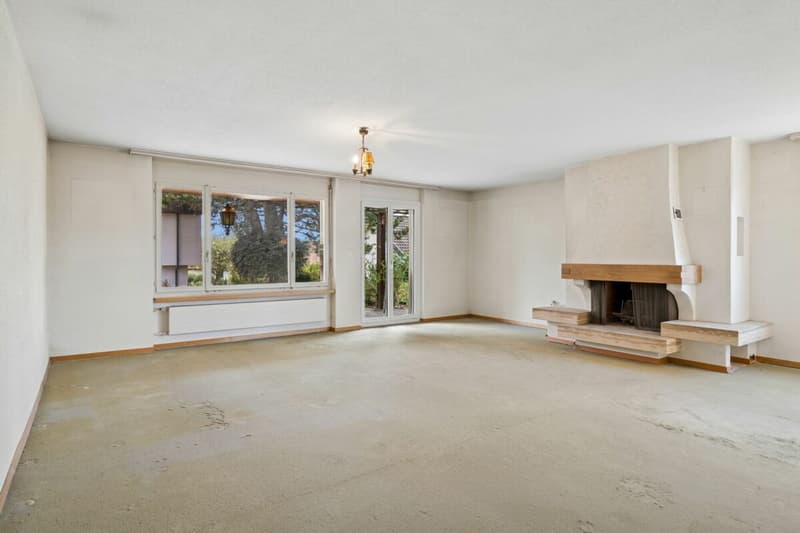 Wohnzimmer mit Cheminée und Zugang zur Terrasse