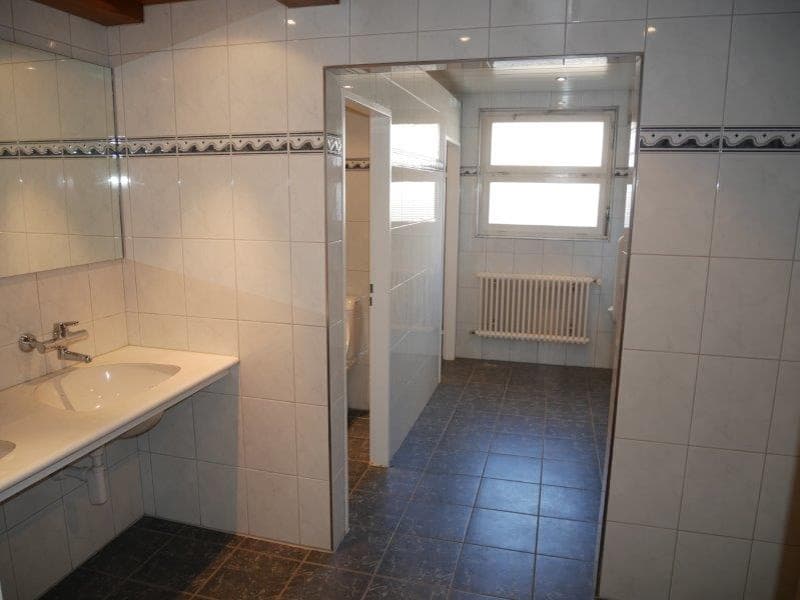 Bathroom with white tiles, two sinks, mirror, radiator, separate shower