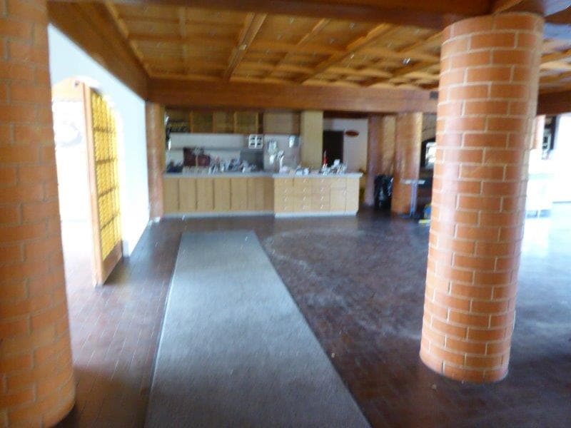 open kitchen, wooden ceiling, brick pillars, wooden floor, long white rug