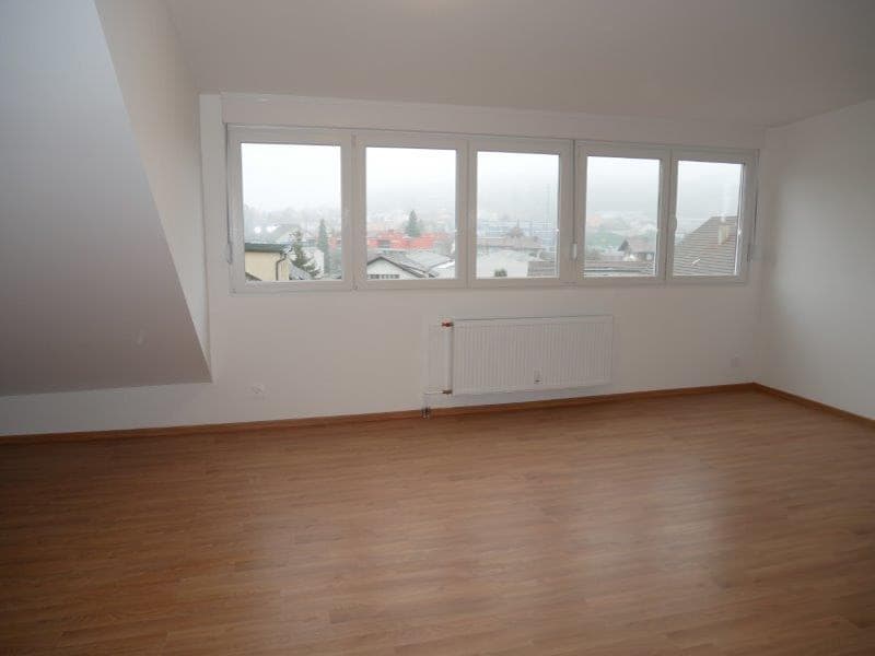 Empty room with hardwood floors, large windows, white walls, white ceiling, radiator, ceiling lamp