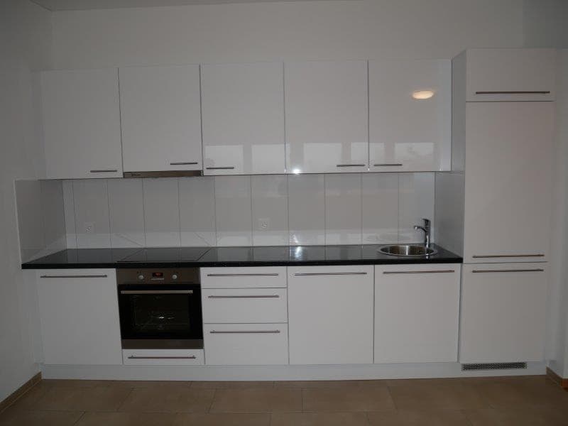 White cabinets, black countertops, stainless steel sink, oven and dishwasher. Modern and clean kitchen