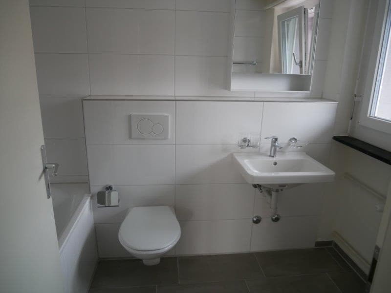 white tiles, modern fixtures, bathtub, toilet, sink, mirror