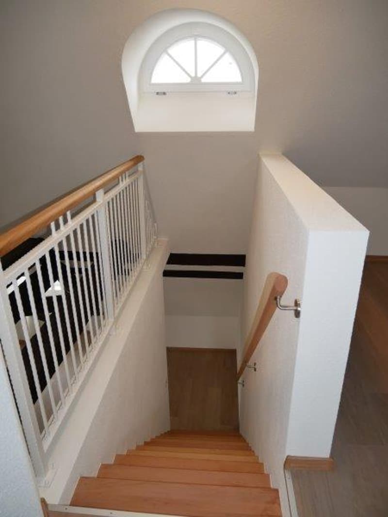wooden stairs, white railing, white walls, arched window