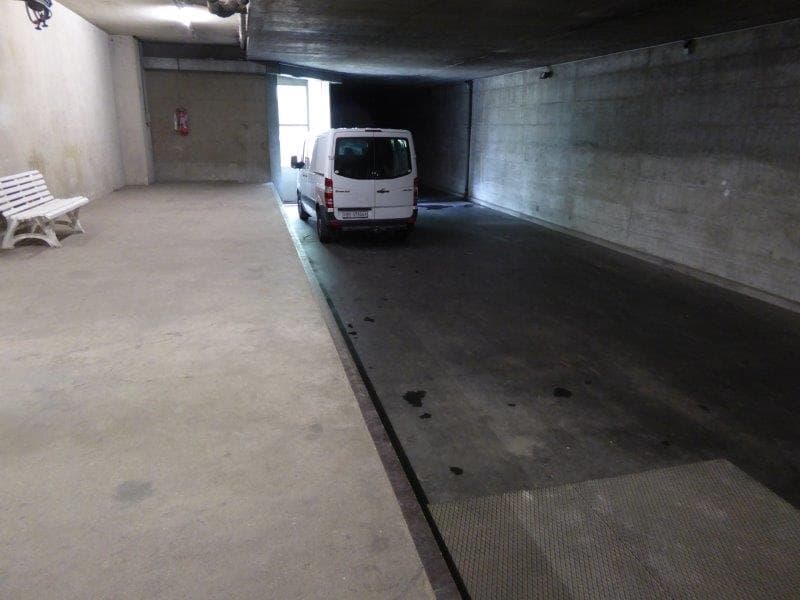 underground parking space, white van, white bench, concrete walls