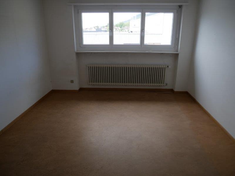 empty room with white walls, wooden floor, window, and a heater