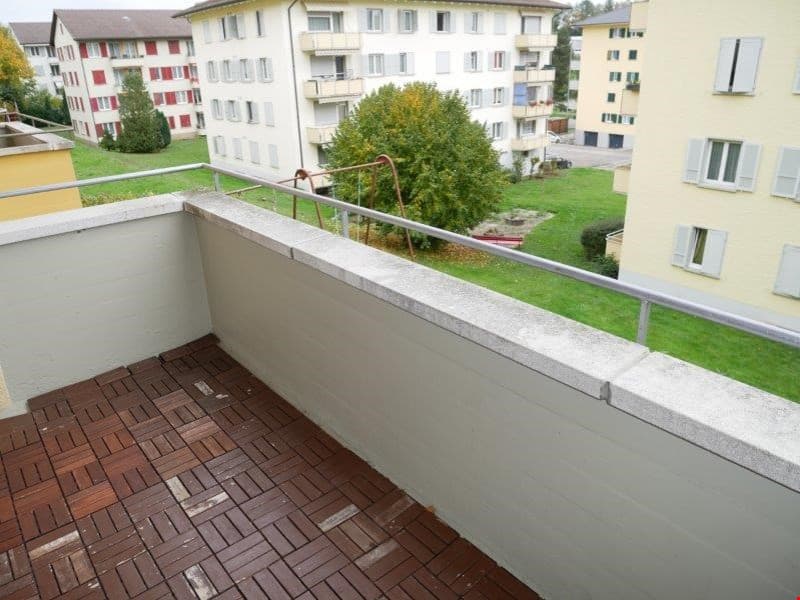 wooden floor, metal railing, overlooking a grassy area with a tree and a swing