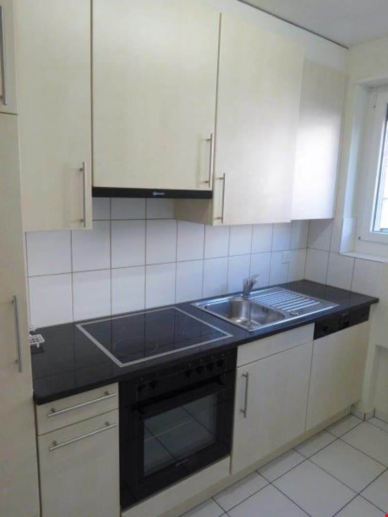 modern kitchen with white cabinets, black countertops, stainless steel sink, electric stove, oven, dishwasher, washing machine