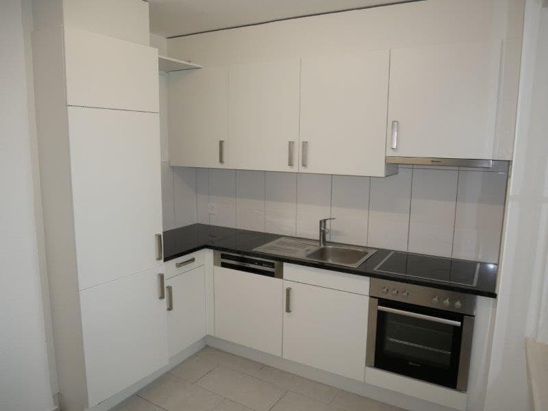 modern kitchen with white cabinets, black countertops, stainless steel sink, dishwasher, oven, and refrigerator