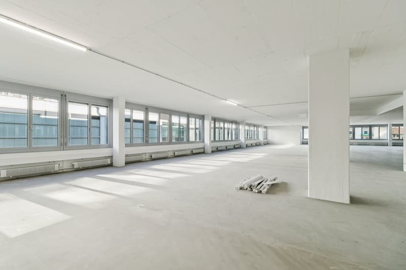 large empty room, white walls, white ceiling, windows, heating system
