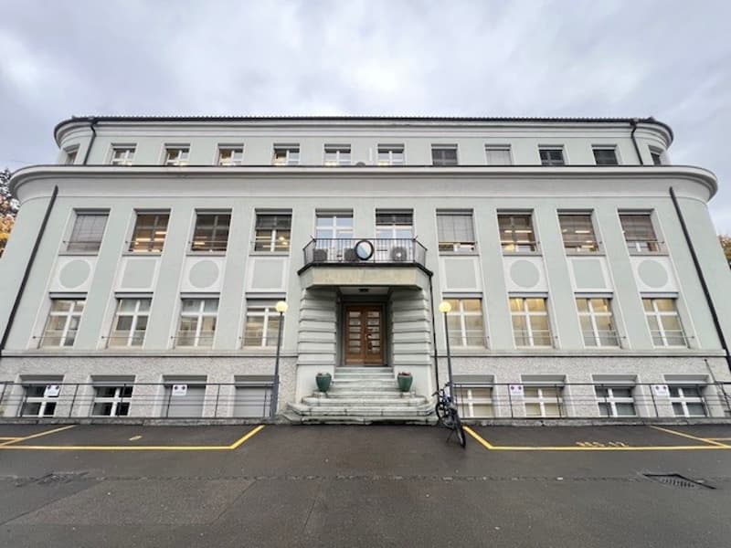 large white building, multiple windows, balcony, stairs, bicycle parked in front
