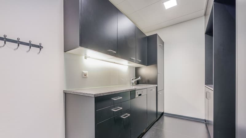 modern kitchen with black cabinets, granite countertop, sink, faucet, dishwasher, electrical outlet