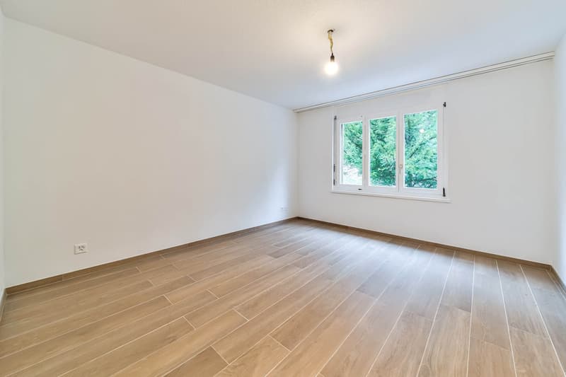wooden floors, white walls, window with outside view