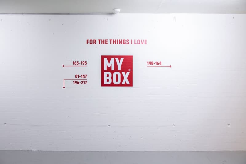 The image shows a white wall with a large red 'MY BOX' logo in the center. Below the logo, there are measurements listed in the format of 165-195, 01-147, 196-217, and 148-164, indicating the dimensions or size range of the 'MY BOX' product.