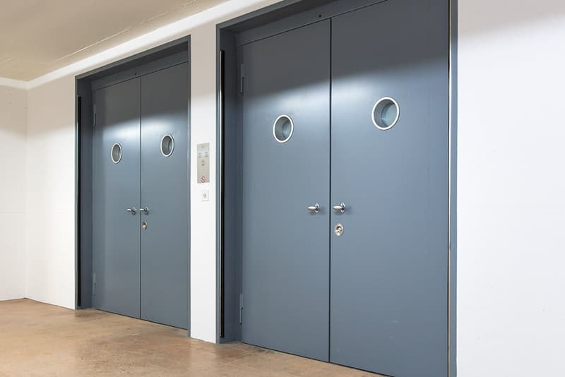 Two closed double metal doors, light switches, vent.