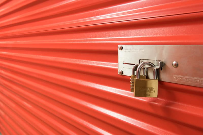 Red metal storage unit with a padlock on the door