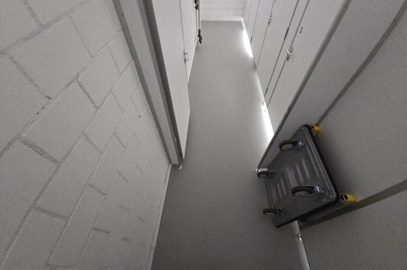 Concrete parking lot with storage closets on one side and a cart in the foreground
