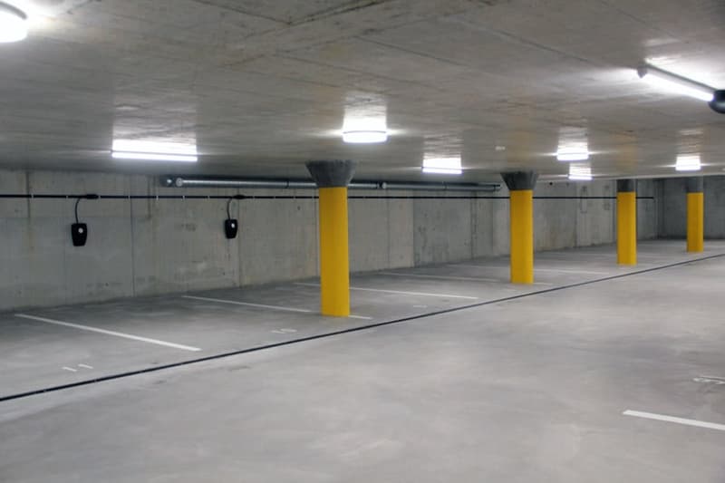 Parking lot, concrete floor, yellow poles, metal pipes, black outlets