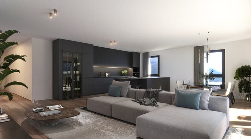 Spacious open-concept living room and kitchen area, with large windows providing natural light. The living room features a comfortable gray sectional sofa, a wooden coffee table, and decorative plants. The kitchen has sleek black cabinetry and appliances,