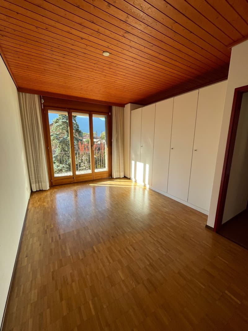 large wooden floor, white walls, sliding doors with balcony, tall white closets