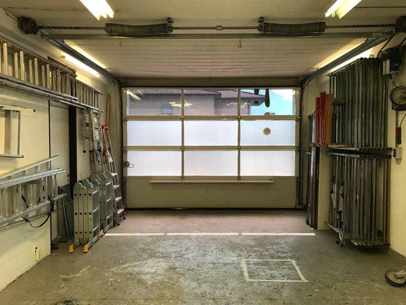 empty garage with ladders, tools, and large windows