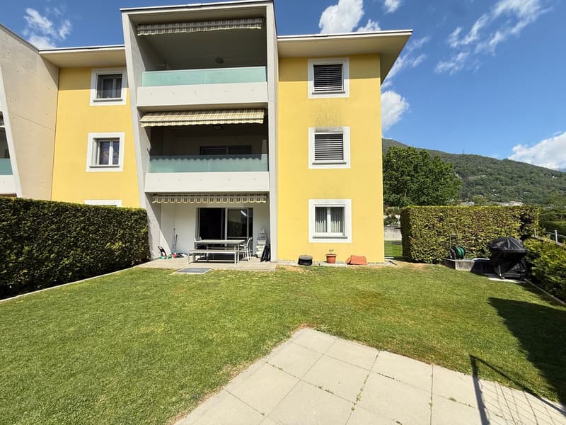 Yellow building, 3 floors, balcony, garden, table, chairs, potted plant