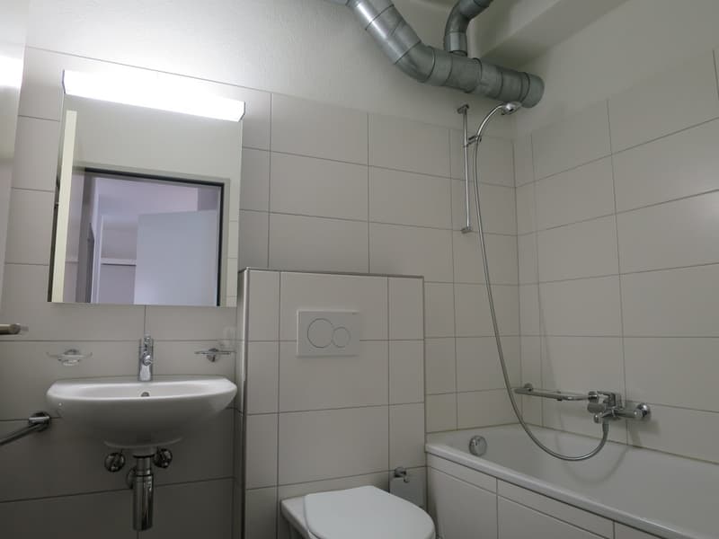white tiles, white sink, white toilet, white bathtub, shower head, mirror