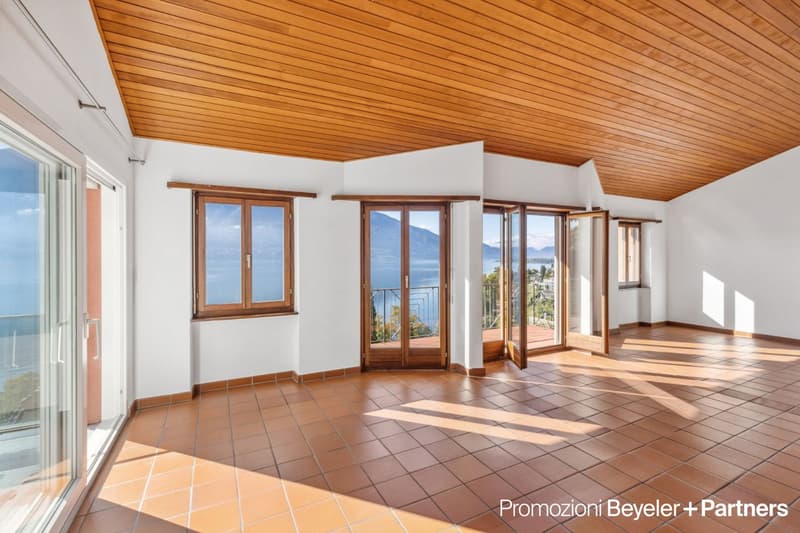 Empty room, tiled floor, wooden ceiling, glass windows, balcony with railing