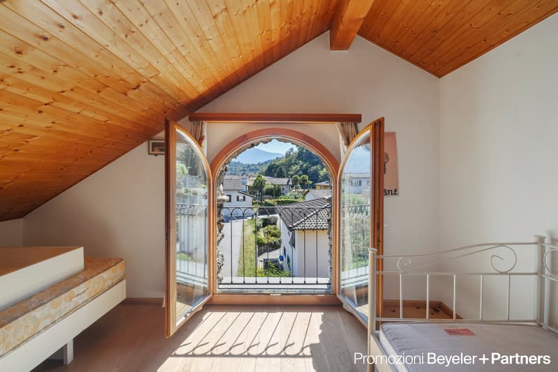 wooden ceiling, open door with balcony, view of outside, wooden floor, bed, iron headboard