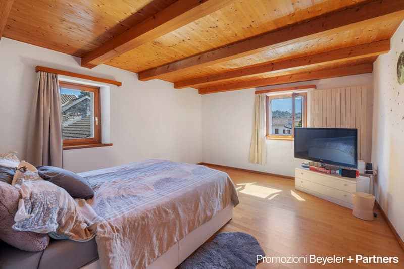 wooden ceiling, wooden floor, bed, pillows, bedspread, window with curtains, television, wooden furniture, area rug