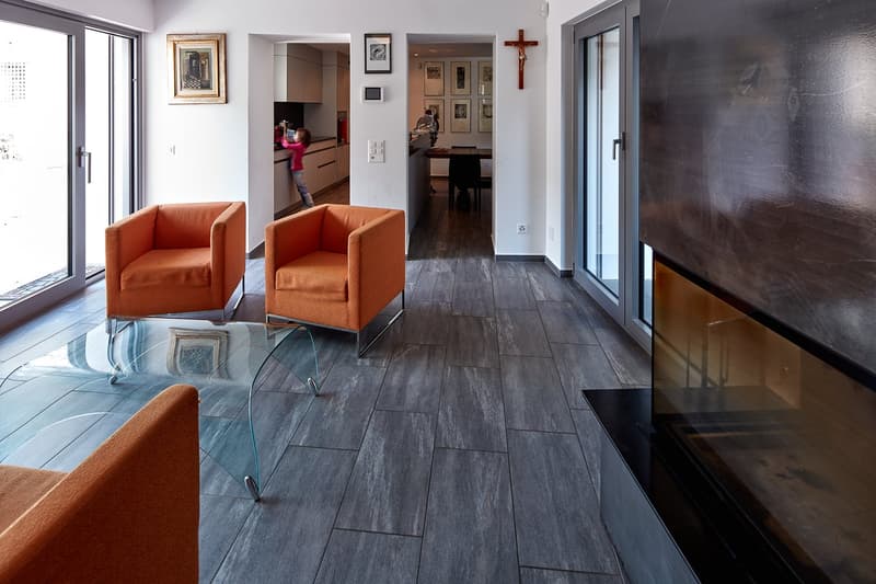 modern living room, fireplace, glass table, orange chairs, wooden floor, glass doors