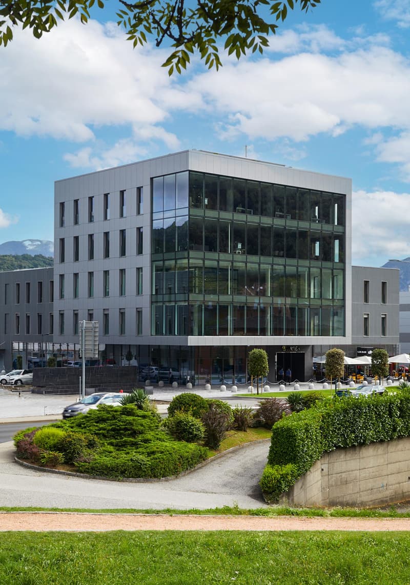 Office building with 5 stories, modern design, glass facade, and parking lot