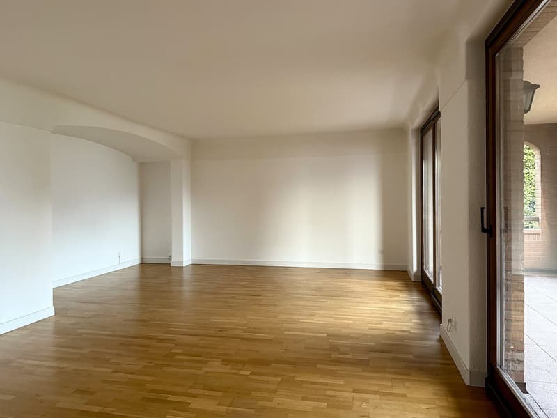 empty room, wooden floor, glass doors leading to balcony, white walls