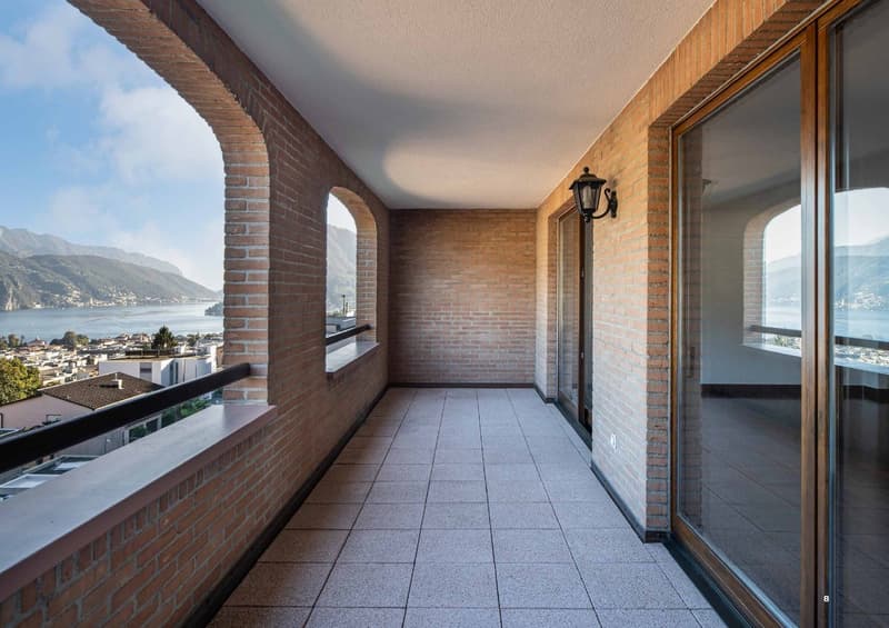 brick walls, tile flooring, balcony with glass railings, panoramic view, lamp